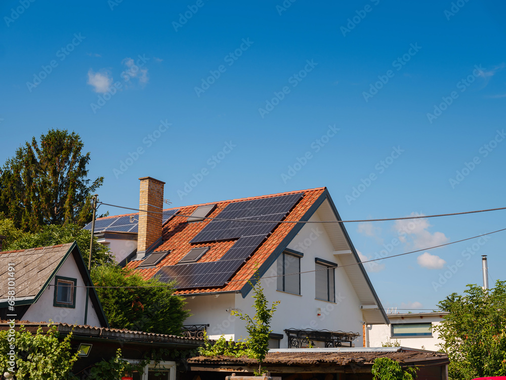 Solar photovoltaic panels on house roof. Modern country house with self-sustaining energy system. Suburb of Vienna, Austria. Idea harnessing clean and sustainable energy, saving money on electricity