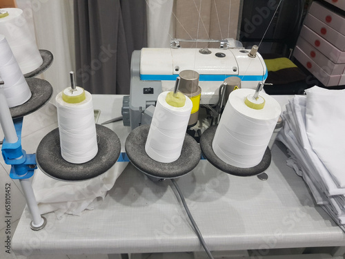 Workshop with overlock sewing machine and thread. Sewing factory manufacture craft business photo