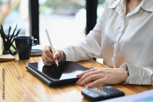 Female entrepreneur using stylus pen writing on digital tablet. Business, technology and communication