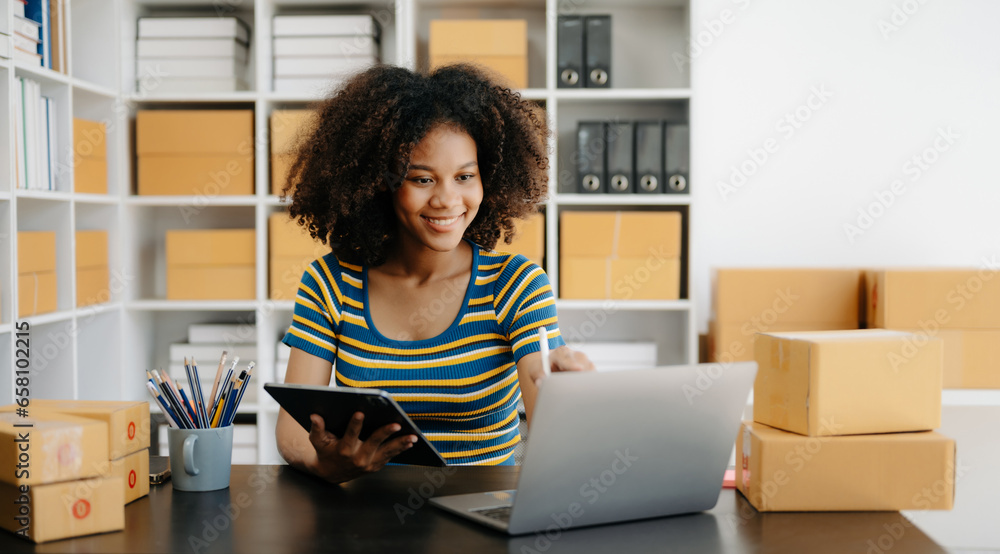 Small business entrepreneur SME freelance African woman working at home office, BOX,tablet and laptop online, marketing, packaging, delivery,  e-commerce concept