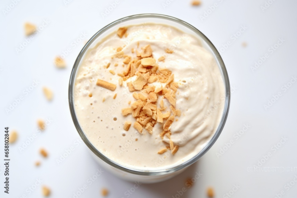 a view of peanut butter milkshake from above on a white tablecloth a view of peanut butter milkshake from above on a white tablecloth