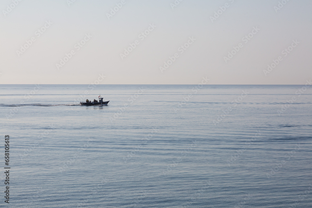 A calm, blue sea with ships sailing in its waters.