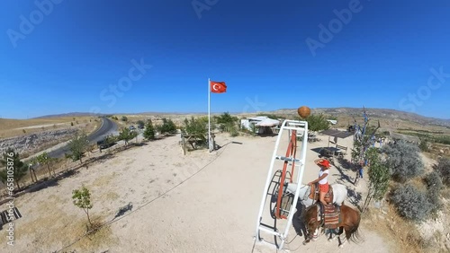 Tourist woman with horses at panoramic view encompasses unique rock sculptures that make the Devrent Valley famous, providing an excellent opportunity to see ethereal beauty of Cappadocian landscape. photo