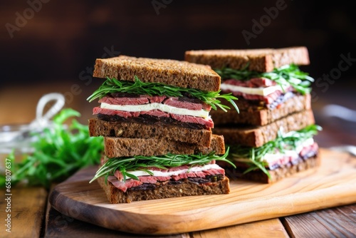 stacked-up rye bread sandwiches on a wooden table