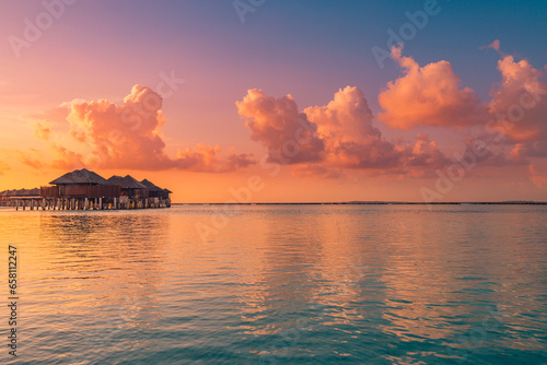 Amazing beach landscape. Beautiful Maldives sunset seascape view. Horizon colorful sea sky clouds, over water villas reflections. Tranquil island lagoon, tourism travel destination. Popular vacation