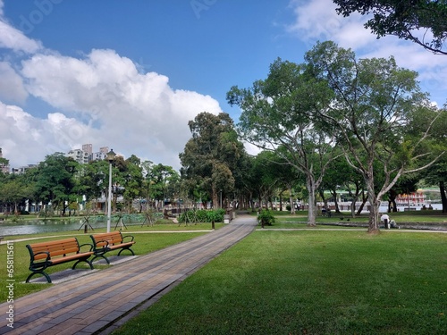 Calm park surrounding with green under a blue sky and withe clouds
