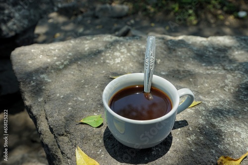Close up a cup of coffee above the rock