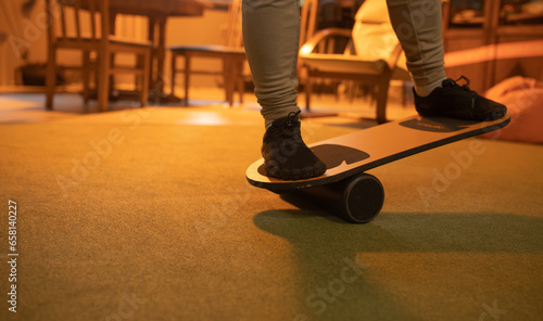 Balance board, close up view with athlete feet. Athlete training with balance board for sports such as surfing and skateboarding.  photo