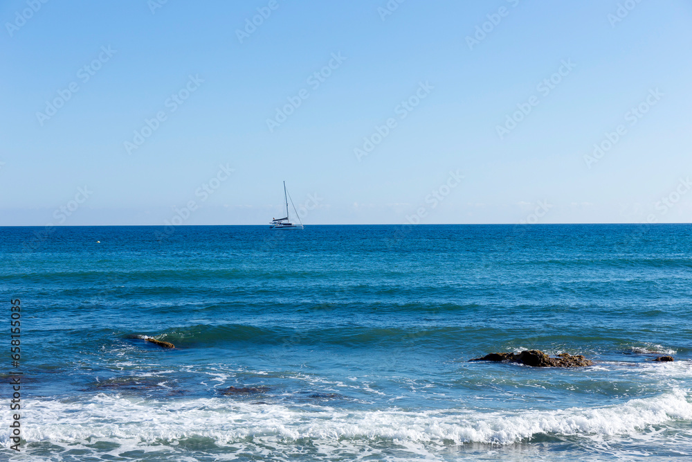 Sea with blue sunny sky and waves in Mijas, Andalusia, Spain