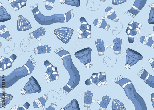 Seamless pattern with winter clothes, scarfs, hats, gloves and mittens and socks wirt snowflakes on a blue background.