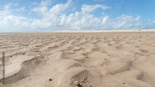 White sand on a deserted beach with blue sky and clouds in the background. Preserved environment.