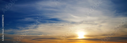 Sunset sky with clouds, blue, orange and yellow clouds and sun background