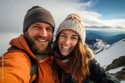 Happy smiling couple of hikers taking selfie picture on top of the mountain - Two travelers smiling together at camera - Travel vloggers using smart mobile phone device