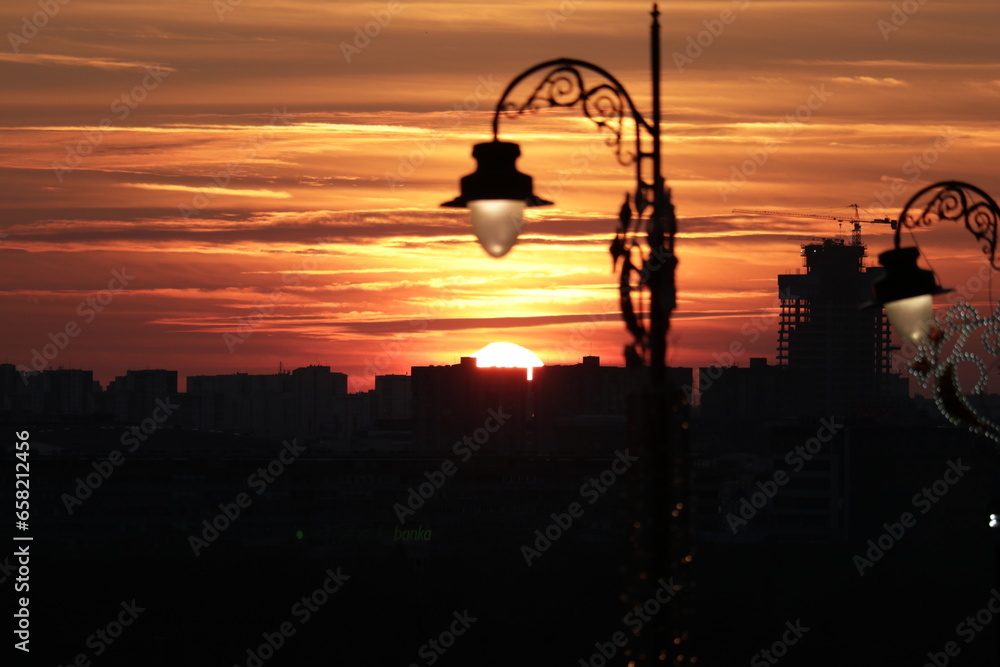 A street light in front of a sunset