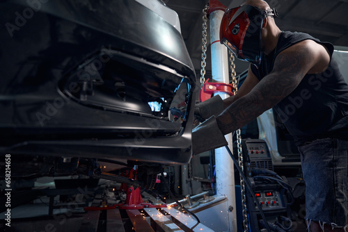 Tableau sur toile Auto-mechanic welding rusted and rotten car sills and fenders