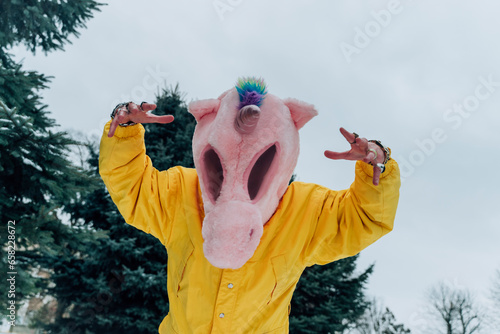 Man in unicorn mask making animal imitation under sky photo