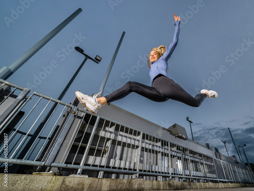 Flexible athlete jumping on river wier photo