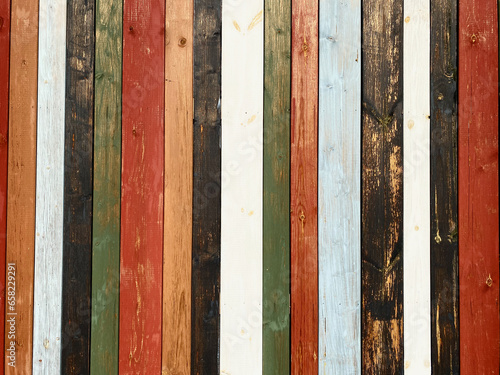 Colorful texture of painted in different bright colors wooden boards close up. Colorful surface of wooden wall from painted boards close-up.