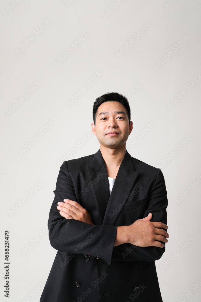 Serious young Asian businessman in black suit isolated indoor. Vertical. Serious young Asian businessman in black suit isolated indoor. Vertical.