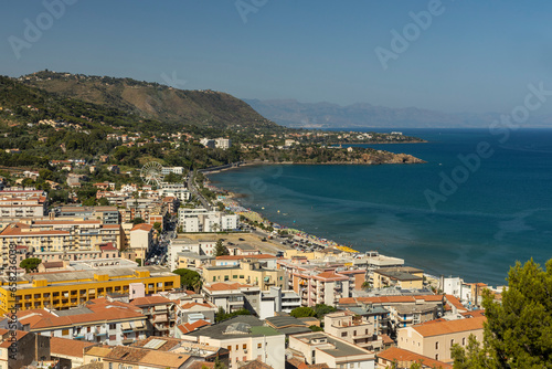 View of Cefalù, the city, the cathedral and its castle. Panorama seen from above of the whole landscape. Rough sea during sunset. The most beautiful places in Sicily. Excellent tourist destination.