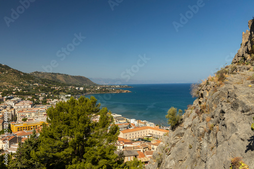 Fototapeta Naklejka Na Ścianę i Meble -  View of Cefalù, the city, the cathedral and its castle. Panorama seen from above of the whole landscape. Rough sea during sunset. The most beautiful places in Sicily. Excellent tourist destination.