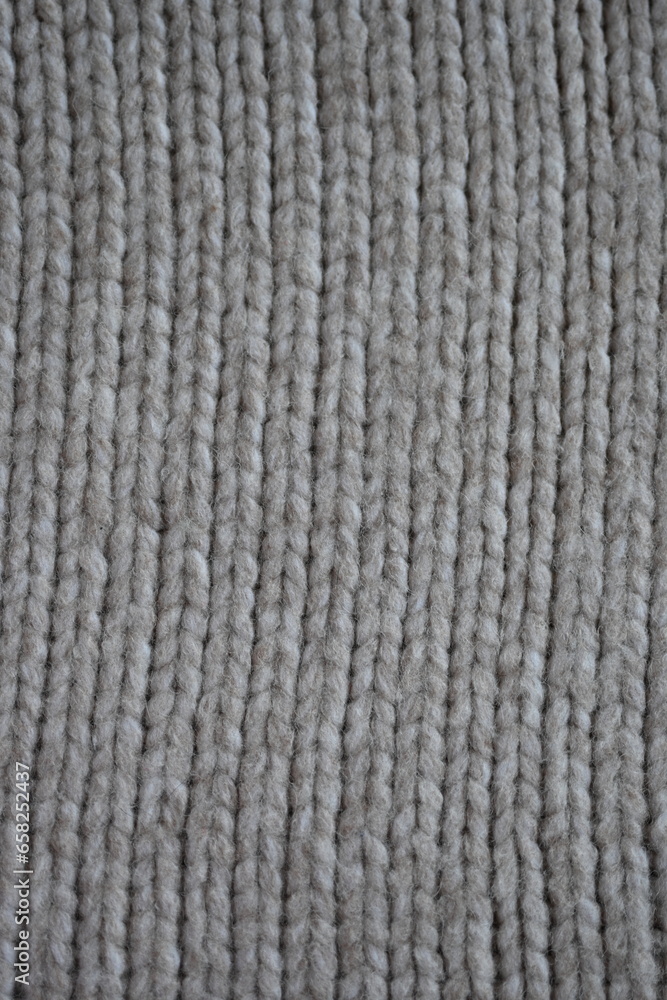 The texture of fabric thick beige sweater close-up. Knitted texture background The texture of fabric thick beige sweater close-up. Knitted texture background