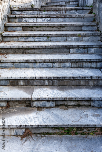 Old abandoned marble staircase in the city park close-up