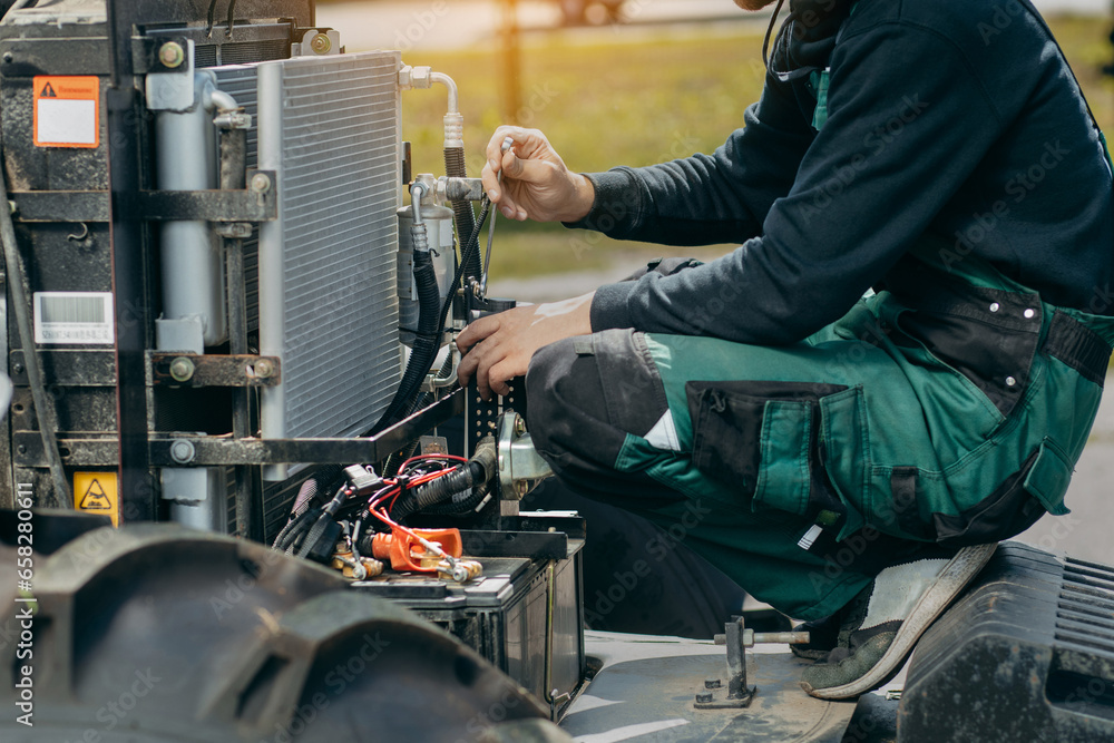 Hands of young mechanic repair tractor Hands of young mechanic repair tractor