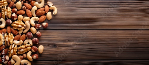 Assorted nuts on wooden backdrop including almonds hazelnuts cashews peanuts and brazilian nuts