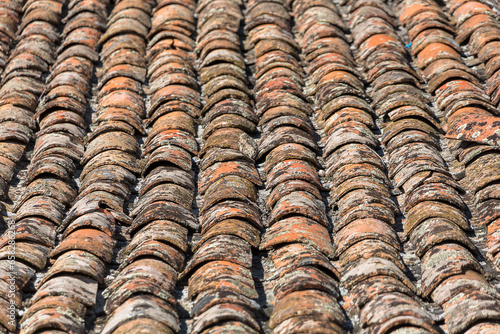 Architecture textures, detailed view of a old and damage italian orange roof tile texture, typical and traditional shale stone material, used on traditional on construction © Miguel Almeida