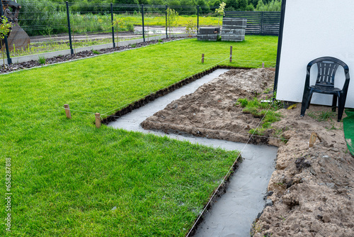 Foundation footings poured in a ditch in the yard, building a terrace in the backyard. photo