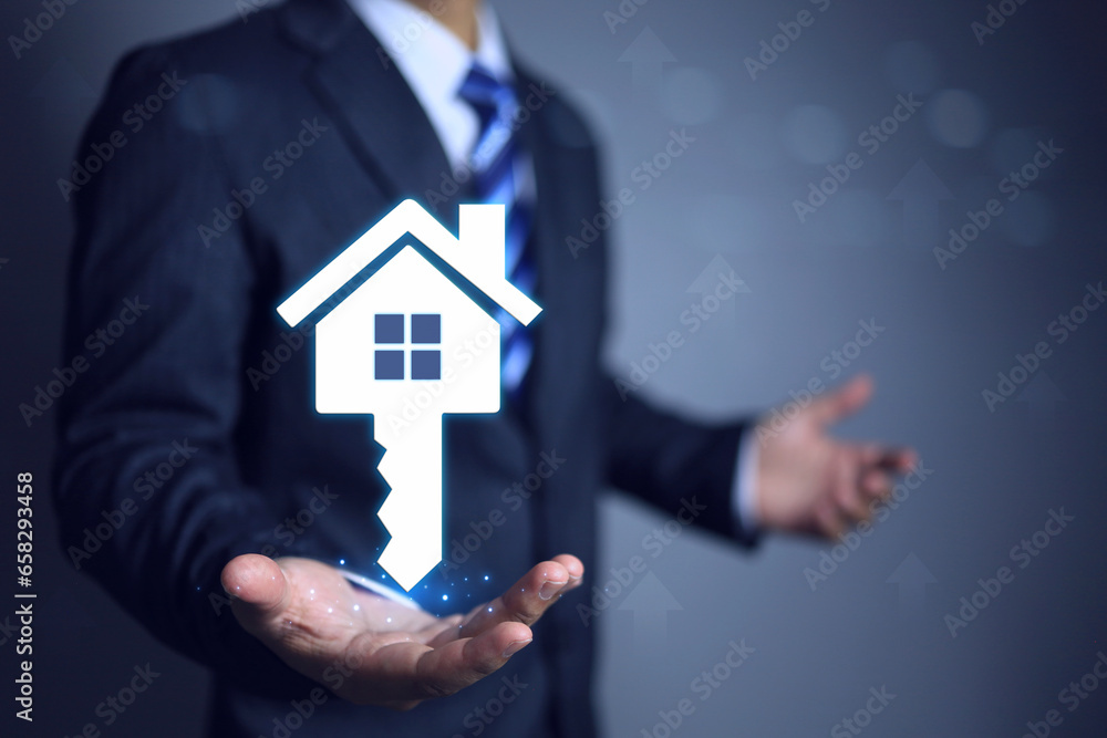 Businessman hold house key in hand, investment and stability in real estate and the reliability of building house with engineering work, giving resident confidence in the quality house. Businessman hold house key in hand, investment and stability in real estate and the reliability of building house with engineering work, giving resident confidence in the quality house.