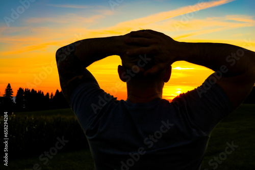 Silhouette eines Mannes der den Sonnenuntergang geniesst