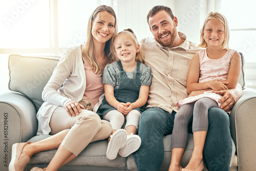 Happy, love and portrait of family on a sofa in the living room bonding and relaxing together at home. Happiness, Smile and girl children sitting with parents from Australia on floor in the lounge.