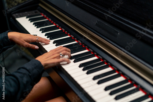 Close-up of a woman's hands in silver rings playing beautiful lyrical melody on the piano keys 