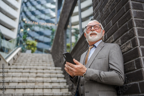One senior man businessman with gray hair use smartphone outdoor © Miljan Živković