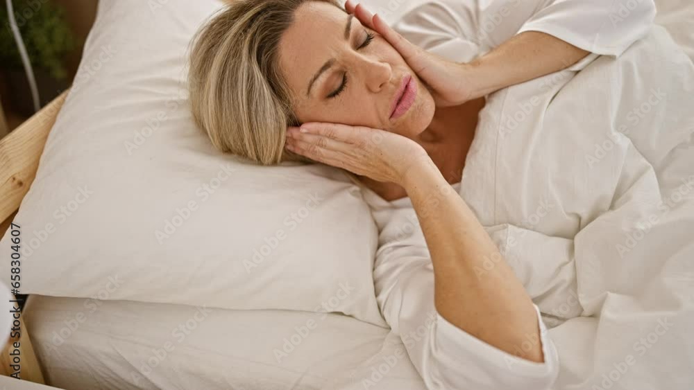 Young blonde woman lying on bed being sick at bedroom Young blonde woman lying on bed being sick at bedroom