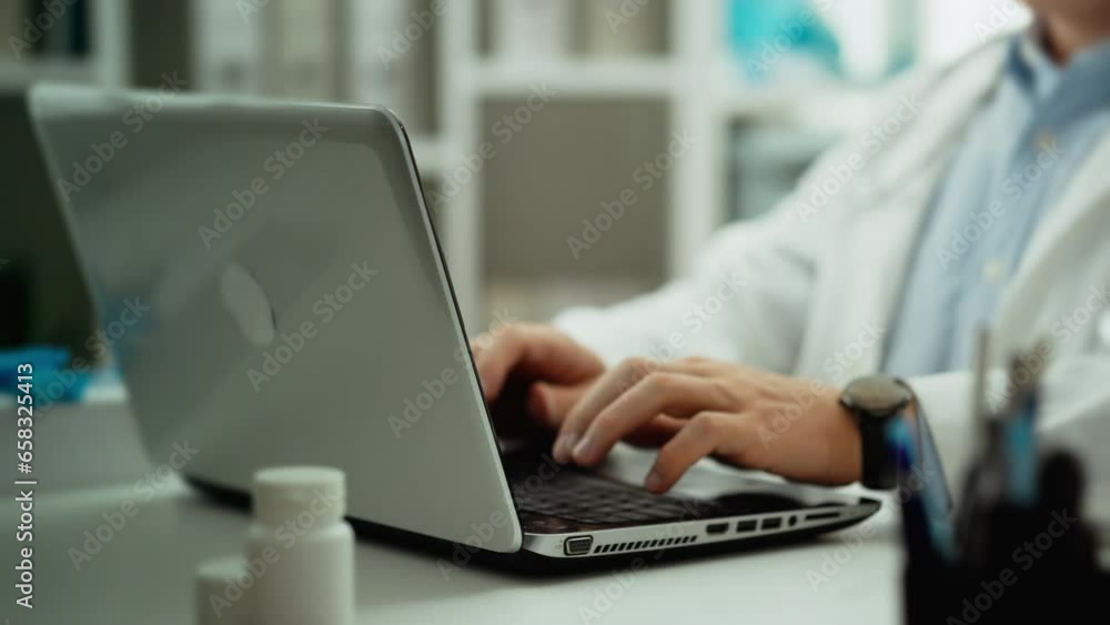 Examination. An experienced doctor dressed as a medical employee works at a laptop in a doctor's waiting room. Close-up of a young man looking into a modern laptop, advanced diagnostic methods, using Examination. An experienced doctor dressed as a medical employee works at a laptop in a doctor's waiting room. Close-up of a young man looking into a modern laptop, advanced diagnostic methods, using