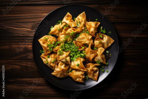 Chinese finger food, fried wontons on the plate close up, top view photo