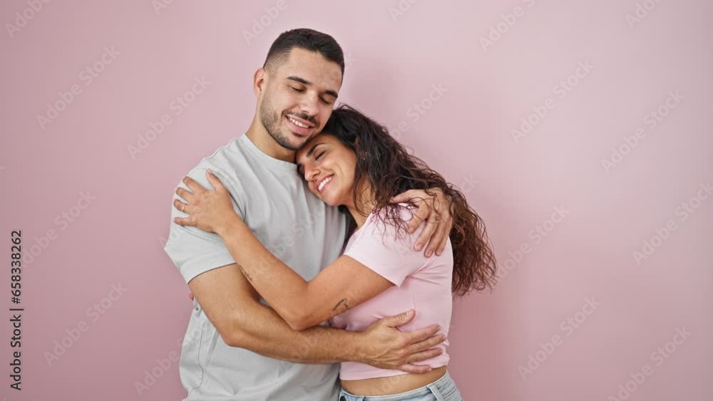 Man and woman couple smiling confident hugging each other over isolated pink background Man and woman couple smiling confident hugging each other over isolated pink background