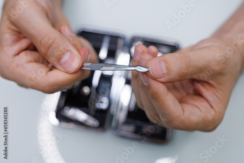 Cleans the dirt from under your fingernails. A man gives himself a manicure