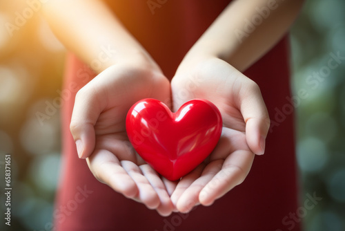 The woman is holding a red heart-shaped object  a symbol of happiness  in her hand. An abstract concept of prayer for peace  wrapped in happiness and blessings.
