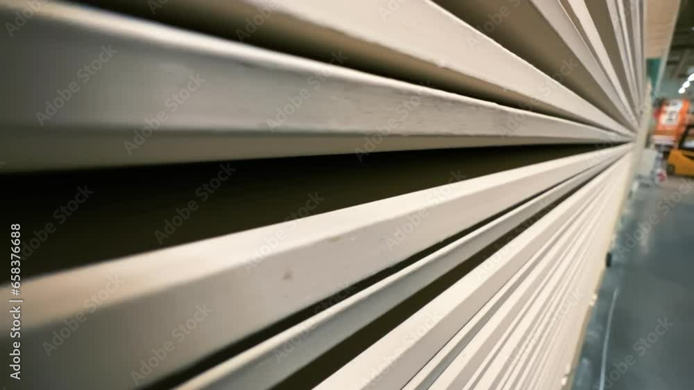 Plasterboard boards or sheetrock stacked in a warehouse of a hardware store or factory. Extreme close-up. Wide angle shot Plasterboard boards or sheetrock stacked in a warehouse of a hardware store or factory. Extreme close-up. Wide angle shot