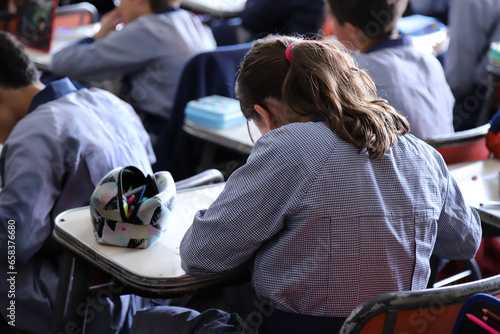 Students doing homework in the classroom. Boys and girls in classes. Primary school students in classes. Students in class at a Catholic school. Education. Children learning at school.