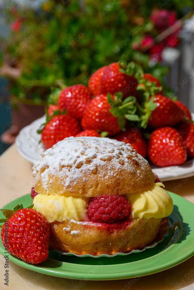 Tarte tropezienne or La Tarte de Saint-Tropez - dessert pastry consisting of filled brioche with cream and fresh berries served outdoor with fresh ripe strawberry Tarte tropezienne or La Tarte de Saint-Tropez - dessert pastry consisting of filled brioche with cream and fresh berries served outdoor with fresh ripe strawberry