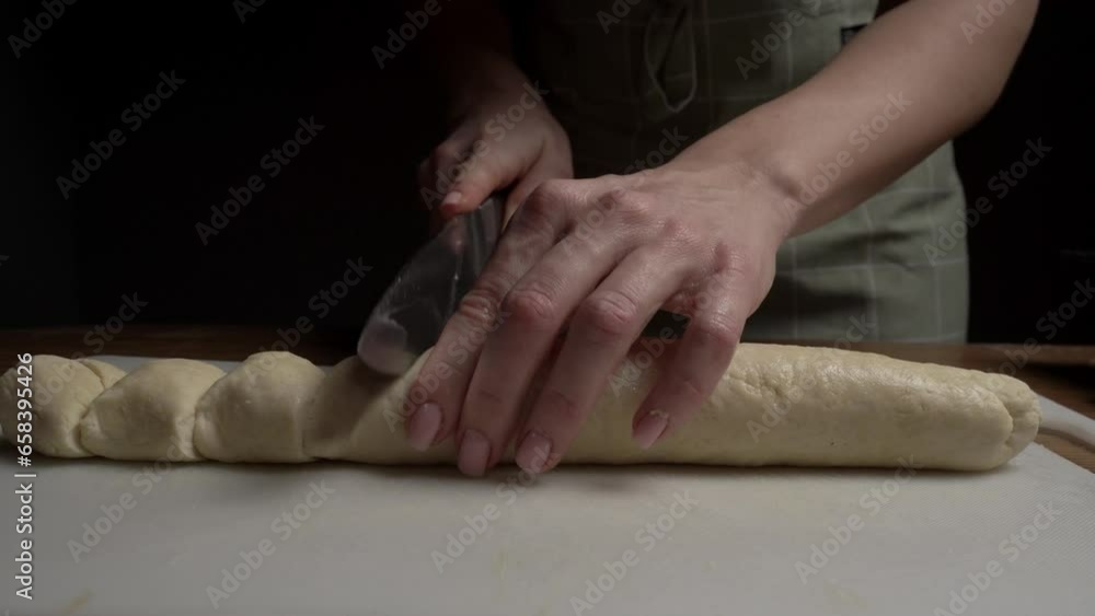 The girl cuts the dough into pieces The girl cuts the dough into pieces
