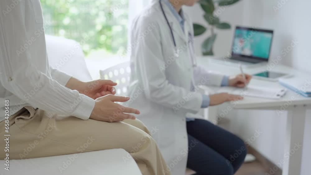 Doctor and patient are in the clinic. Young woman is sitting on sofa and talking to a pediatrician who is using a clipboard for making medical notes. Medicine, healthcare concepts Doctor and patient are in the clinic. Young woman is sitting on sofa and talking to a pediatrician who is using a clipboard for making medical notes. Medicine, healthcare concepts