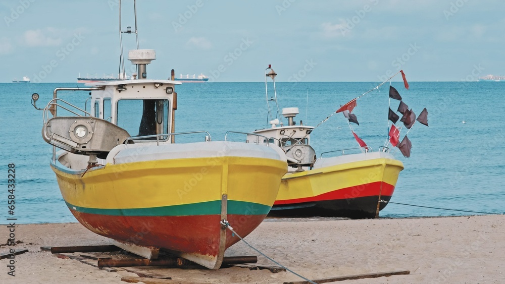 Undecked Handliner Fishing Vessel with Net Flags and Rusty Hooks Purse Sein Equipment Parked on Beach Sand at Seashore on Calm Day