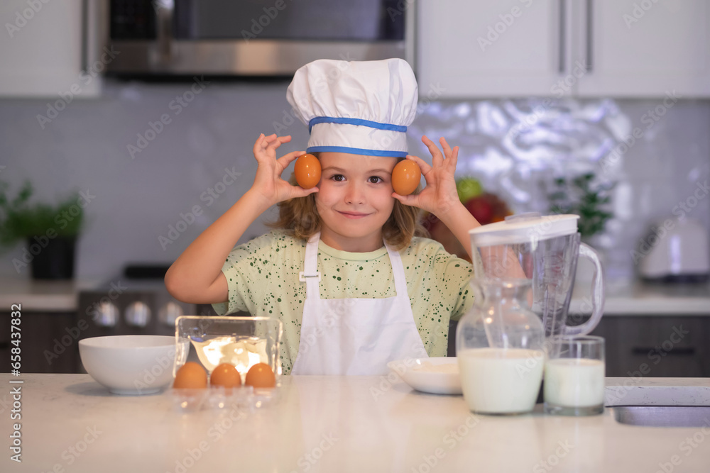 Child chef cook with eggs. Children cooking in the kitchen. Funny kid chef cook cookery at kitchen. Chef kid boy making healthy food. Portrait of little child in chef hat. Child chef cook with eggs. Children cooking in the kitchen. Funny kid chef cook cookery at kitchen. Chef kid boy making healthy food. Portrait of little child in chef hat.