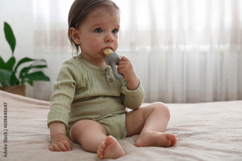 Cute baby girl with nibbler on bed at home Cute baby girl with nibbler on bed at home